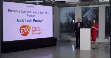 Ceremonia ogłoszenia laureatów konkursu CEE Business Services Summit&Awards. Na zdjęciu osoby prowadzące galę oraz ekran, na który wyświetlono nazwę laureata w kategorii poznańska firma roku z sektora usług biznesowych - GSK Tech Poznań.