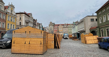 Galeria zdjęć przedstawia montaż drewnianych domków handlowych na Starym Rynku.