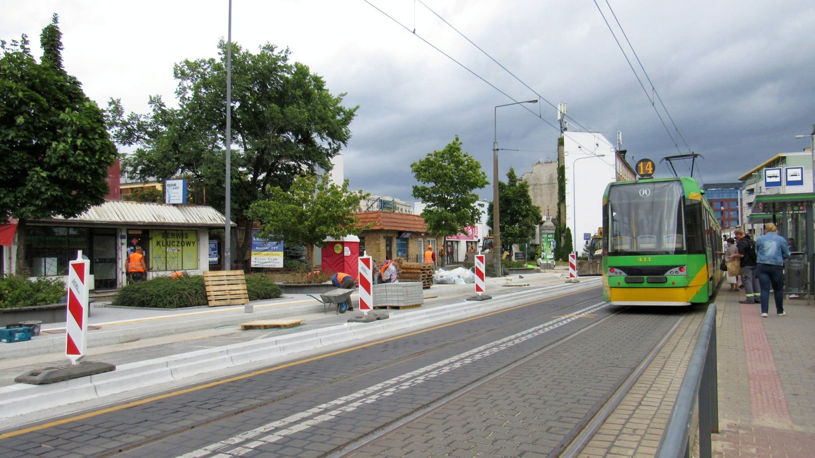 Dwa przystanki tramwajowe. Przy jednym stoi tramwaj, drugi przerabiany jest na wiedeński, widać płyty i słupki ostrzegające - grafika artykułu