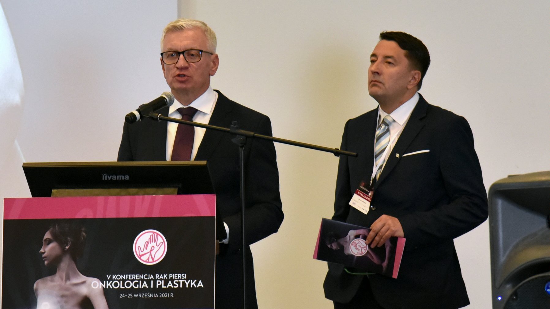 Na zdjęciu Jacek Jaśkowiak, prezydent Poznania, przy mikrofonie, obok prof. Dawid Murawa - grafika artykułu