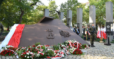 Zdjęcie przedstawia pomnik Polskiego Państwa Podziemnego. Pod nim leżą kwiaty.