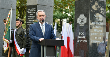 Zdjęcie przedstawia marszałka województwa wielkopolskiego przemawiającego za mównicą.