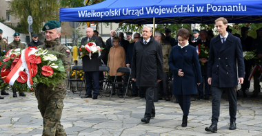 Na zdjęciu przedstawiciele władz miasta i województwa obok siebie, przed nimi żołnierz trzymający wiązankę kwiatów