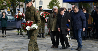 Na zdjęciu przedstawiciele kombatantów, przed nimi żołnierz trzymający wiązankę kwiatów