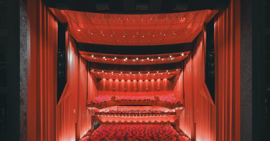 Wizualizacja: widok na widownię teatru, na pierwszym planie scena, w tle czerwone krzesła i kotary na widowni