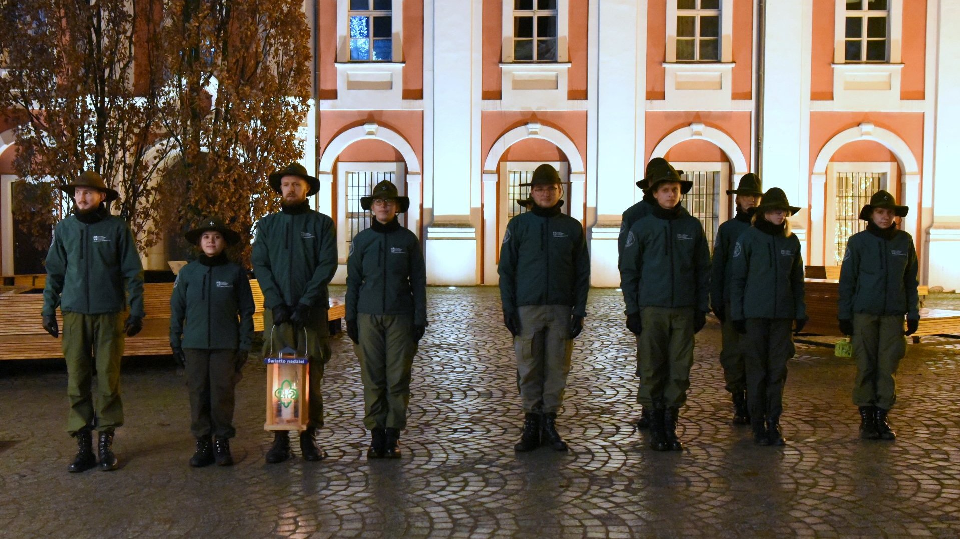 Zdjęcie przedstawia harcerzy stojących na dziedzińcu urzędu.