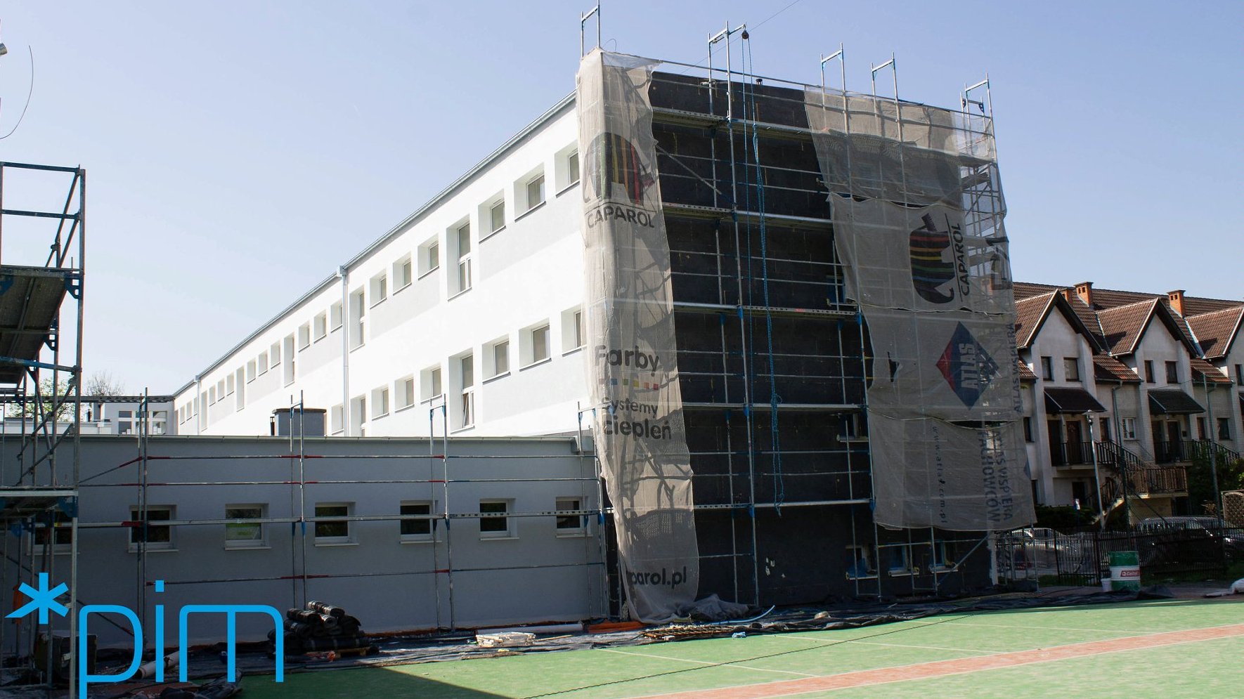 Galeria zdjęć przedstawia budynek szkoły, w którym prowadzone są prace termomodernizacyjne. Widać na nim m.in. rusztowania. - grafika artykułu