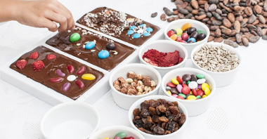 Zdjęcie przedstawia czekolady i składniki w miseczkach.