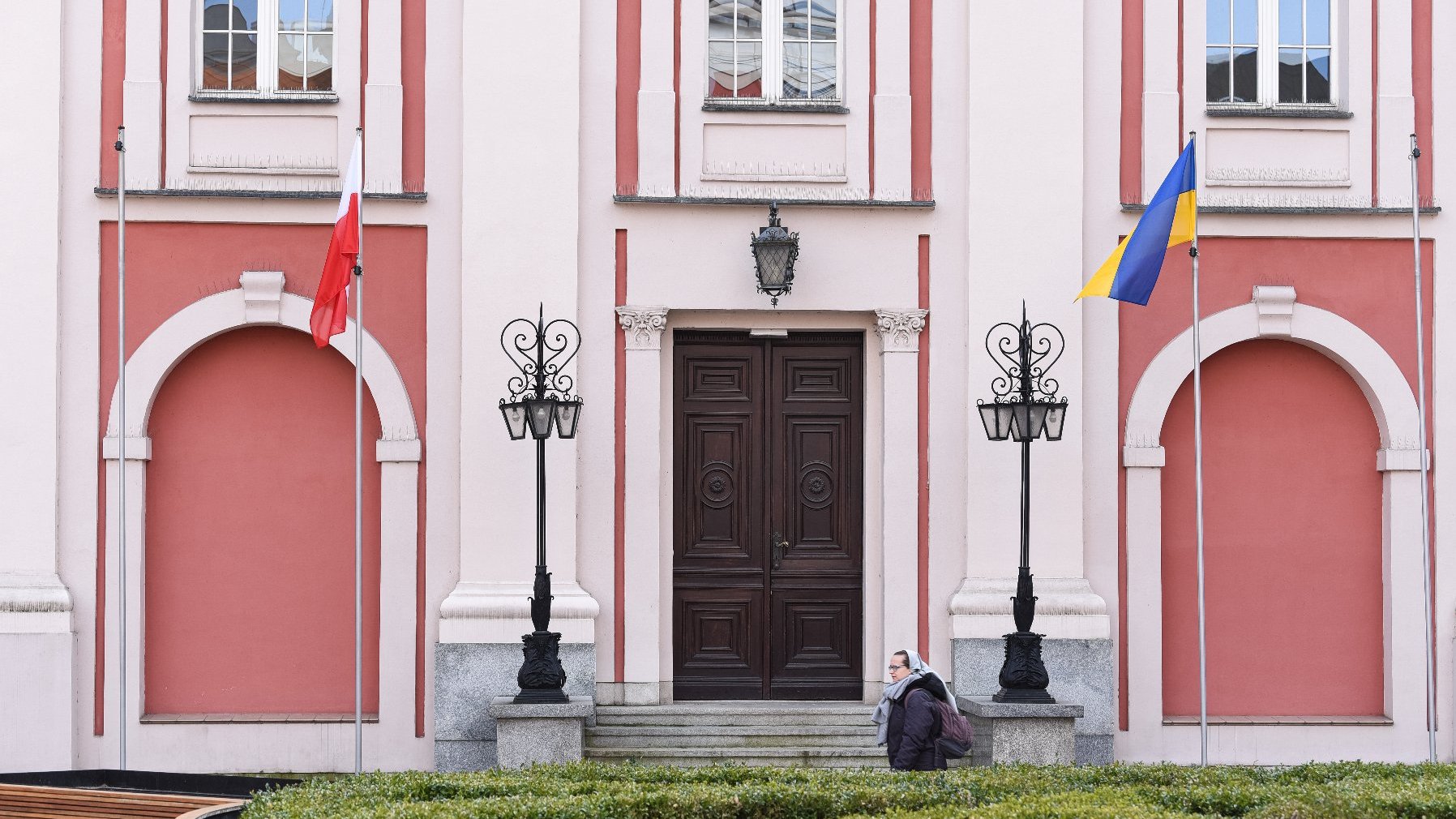 Na zdjęciu budynek urzędu na placu Kolegiackim, przed nim dwie flagi: Polski i Ukrainy - grafika artykułu