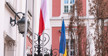 Na zdjęciu budynek urzędu na placu Kolegiackim, przed nim dwie flagi: Polski i Ukrainy