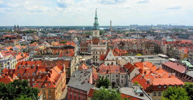 Na zdjęciu panorama Poznania z lotu ptaka, w centrum Ratusz i dachy kamienic