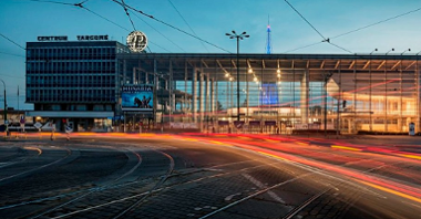 Na zdjęciu wejście główne na Międzynarodowe Targi Poznańskie, na pierwszym planie ślady świateł samochodów
