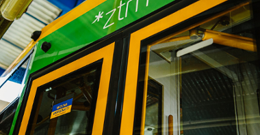 Niebiesko-żółta naklejka z napisem Wolna Ukraina po polsku i ukraińsku naklejona na drzwiach autobusu