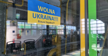 Niebiesko-żółta naklejka z napisem Wolna Ukraina po polsku i ukraińsku naklejona na drzwiach tramwaju