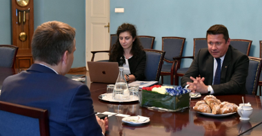 Na zdjęciu ambasador Rumunii przy stole, rozmawia z zastępcą prezydenta Poznania (tyłem do obiektywu), obok kobieta