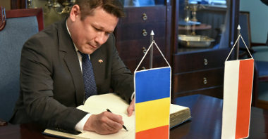 Na zdjęciu ambasador Rumunii wpisuje się do księgi pamiątkowej