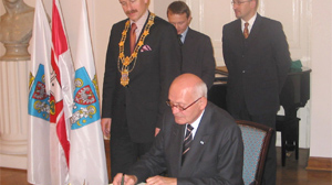 nadburmistrz Hanoweru Herbert Schmalstieg wpisuje się do Księgi Pamiątkowej Poznania