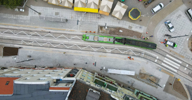 Na zdjęciu torowisko z otu ptaka, w centrum tramwaj, widać dachy straganów na targowisku