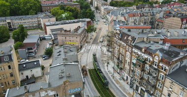Na zdjęciu torowisko z lotu ptaka, w centrum widać tramwaj, w tle widać panoramę Poznania