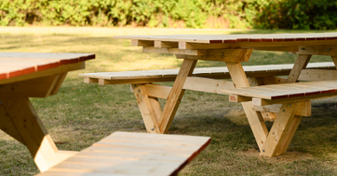 Na zdjęciu drewniane meble - stoły i ławki