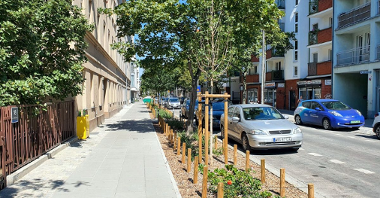 Zdjęcie przedstawia ulicę Umińskiego. W lewej i sprawej strony widać kamienice, w środku kadru zieleń, chodnik i jezdania, z zaparkowanymi na niej samochodami.