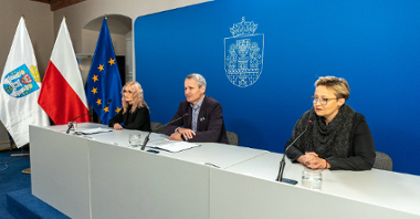 Na zdjęciu trzy osoby za stołem konferencyjnym, w środku Jędrzej Solarski, zastępca prezydenta Poznania