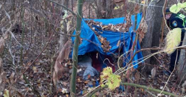 Na zdjęciu miejsce przebywania osób w kryzysie bezdomności. Widać namiot między drzewami