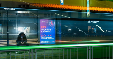 Na zdjęciu przystanek tramwajowy, na wiacie plakat informujący o testach na HIV