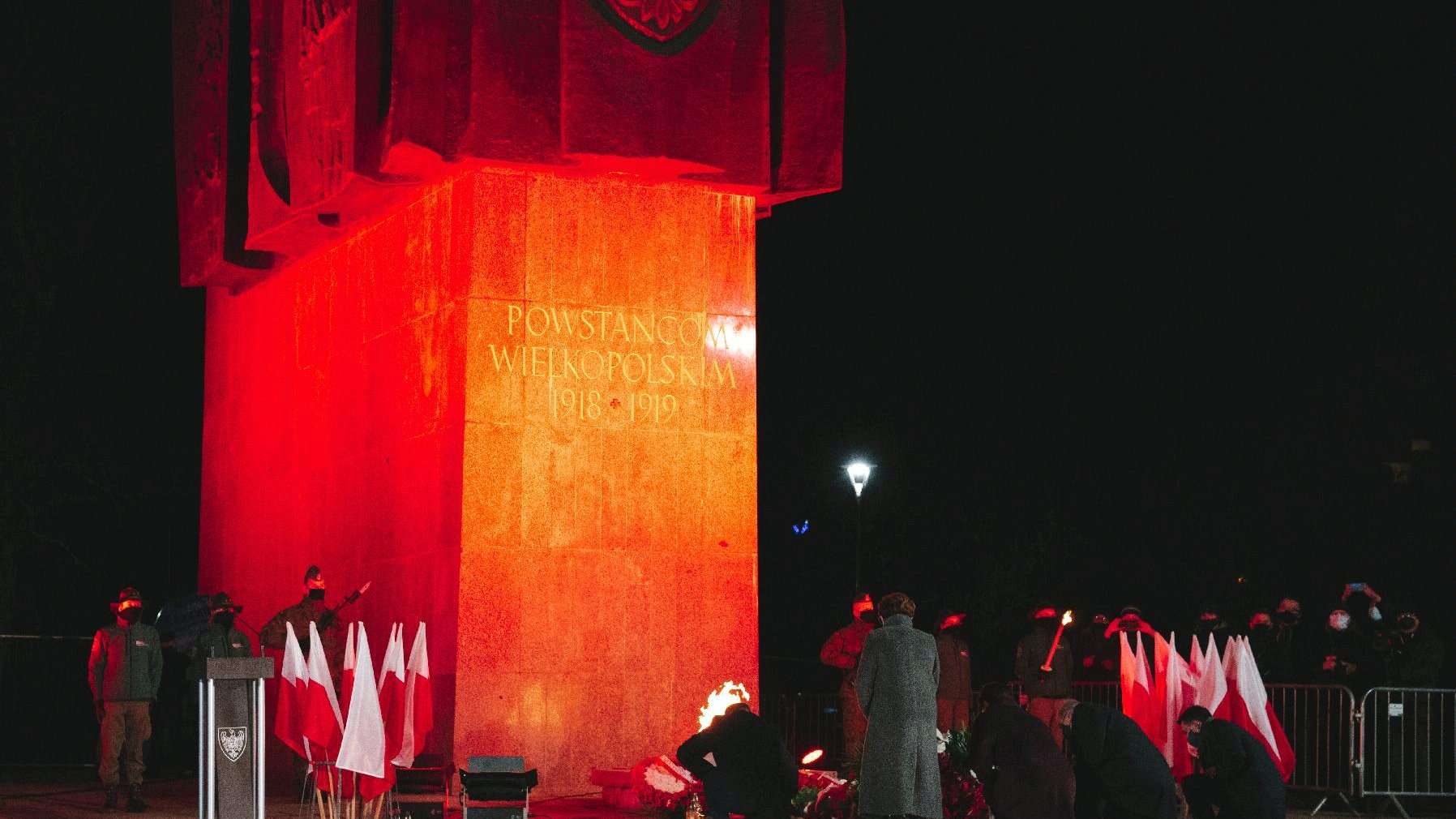 Podświetlony na czerwono pomnik Powstania Wielkopolskiego. - grafika artykułu