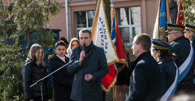 Na zdjęciu zastępca prezydenta Poznania przy mikrofonie, w tle poczet sztandarowy