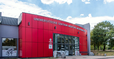 Na zdjęciu czerwono-szary budynek azylu z napisem "Uniwersyteckie Centrum Medycyny Weterynaryjnej"