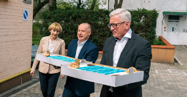 Na zdjęciu trzy osoby - w tym prezydent Poznania - niosące tort