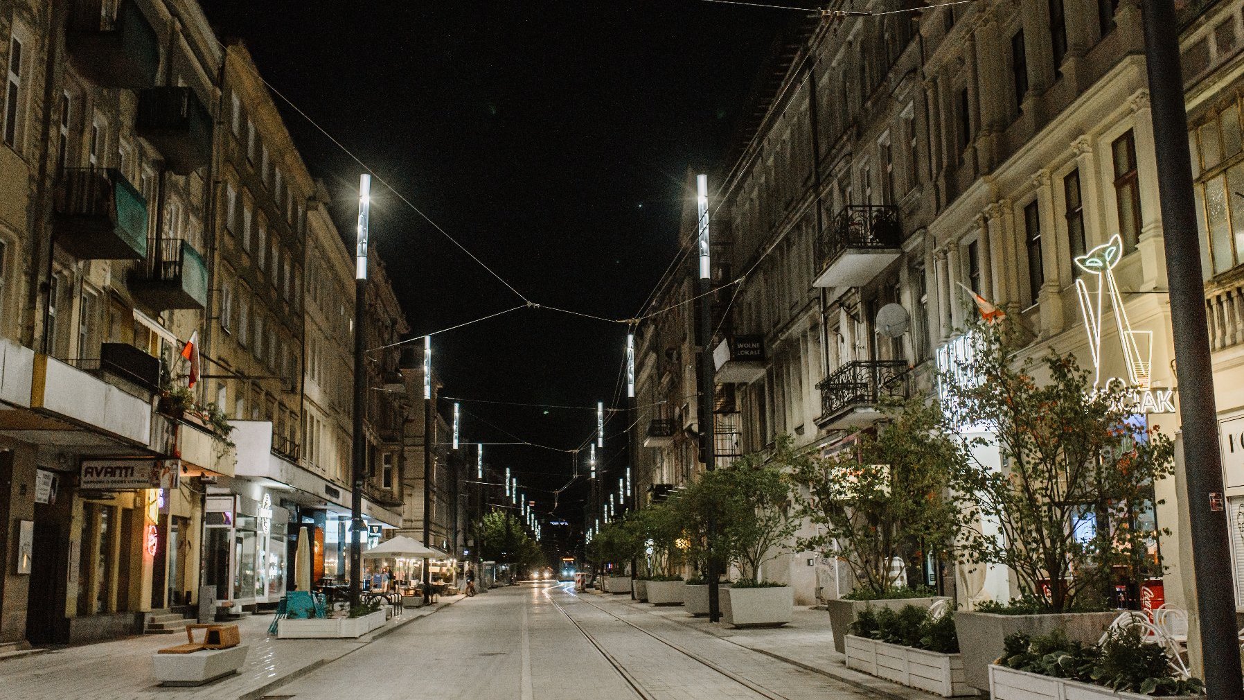 Na zdjęciu ulica Święty Marcin nocą, na niej neony - grafika artykułu