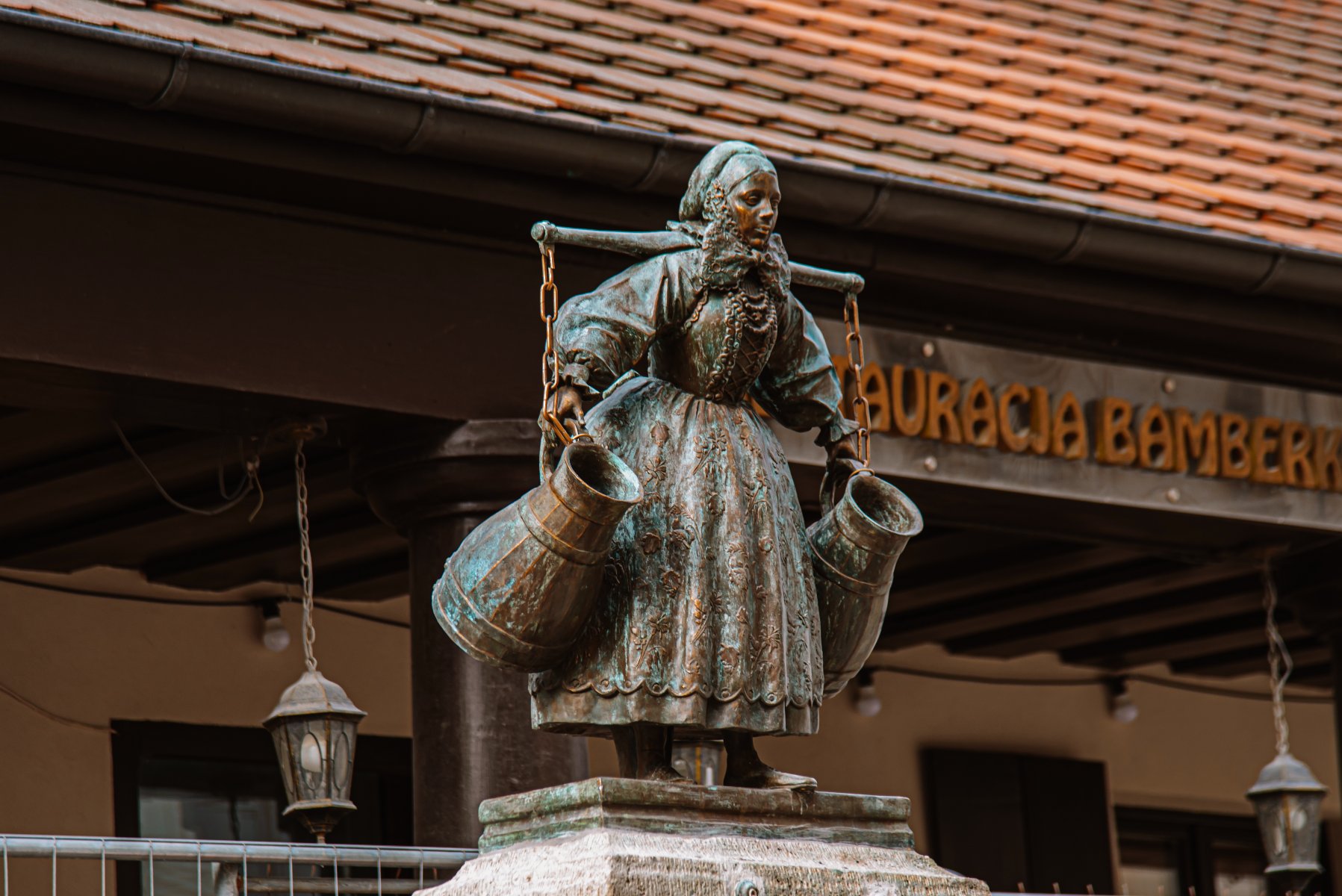 Na zdjęciu Bamberka: figurka z brązku przedstawiająca kobietę z dwoma naczyniami na wodę - grafika artykułu
