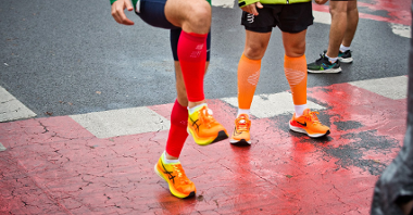 Zdjęcie przedstawia nogi dwóch mężczyzn w sportowych butach.