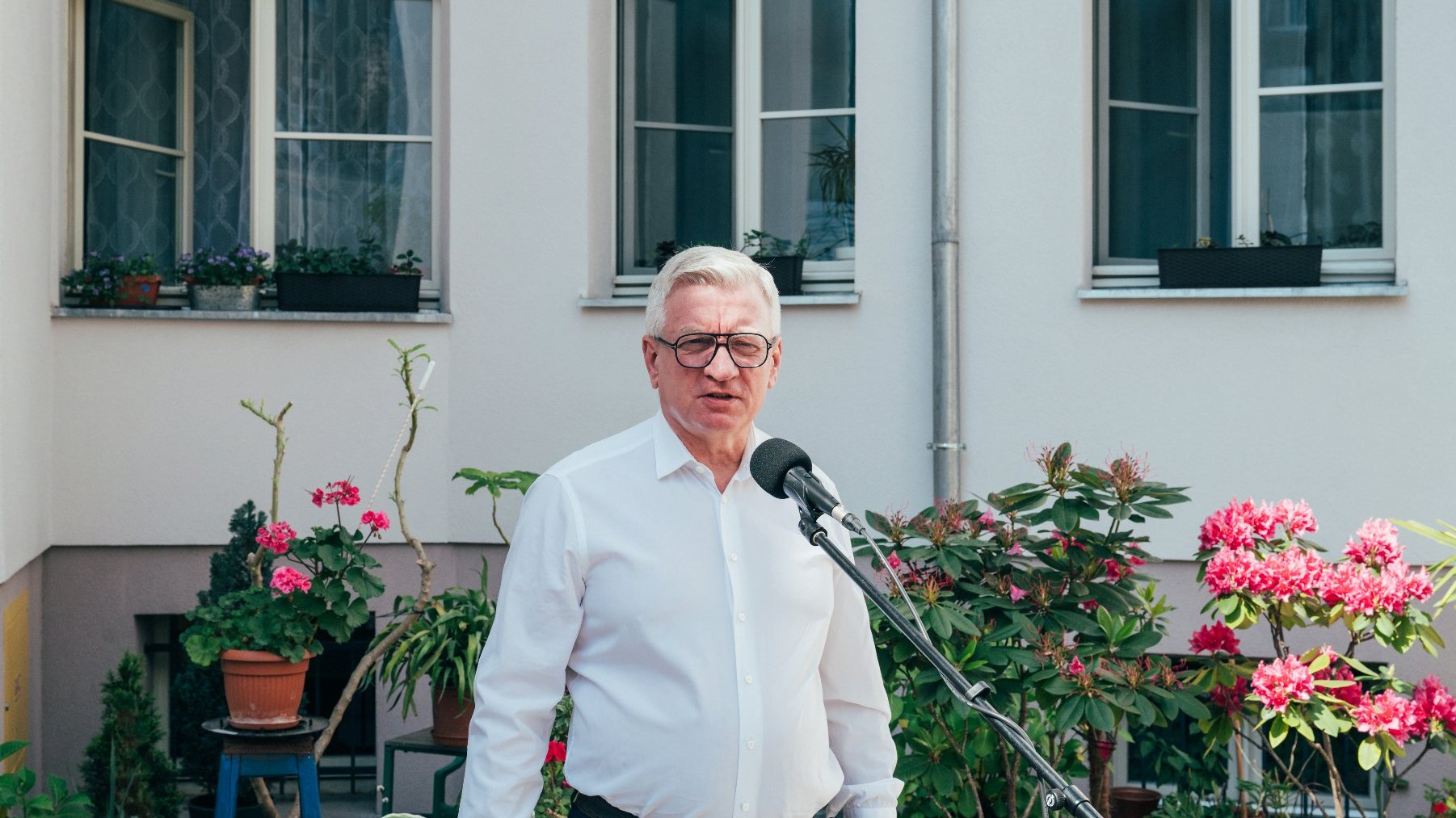 Na zdjęciu prezydent Poznania przed mikrofonem na podwórku