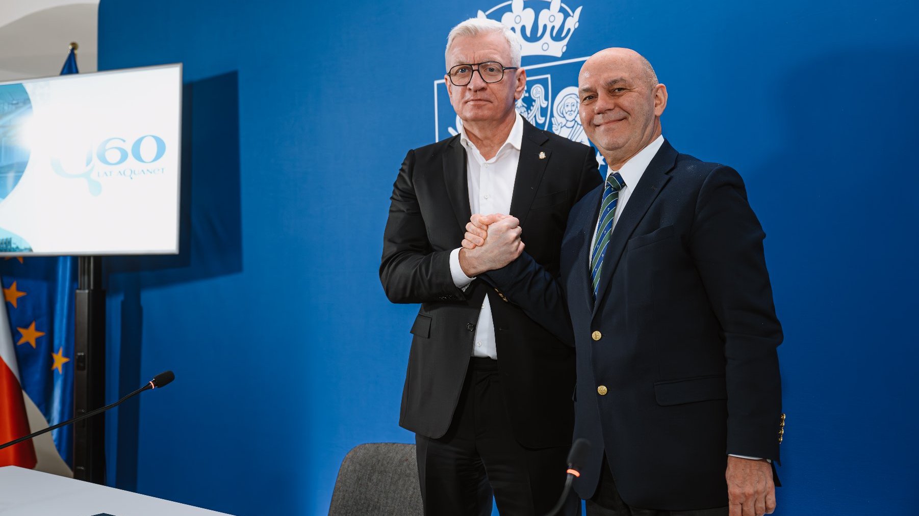 Zdjęcie przedstawia prezydenta Poznania i prezesa Aquanetu podających sobie ręce.