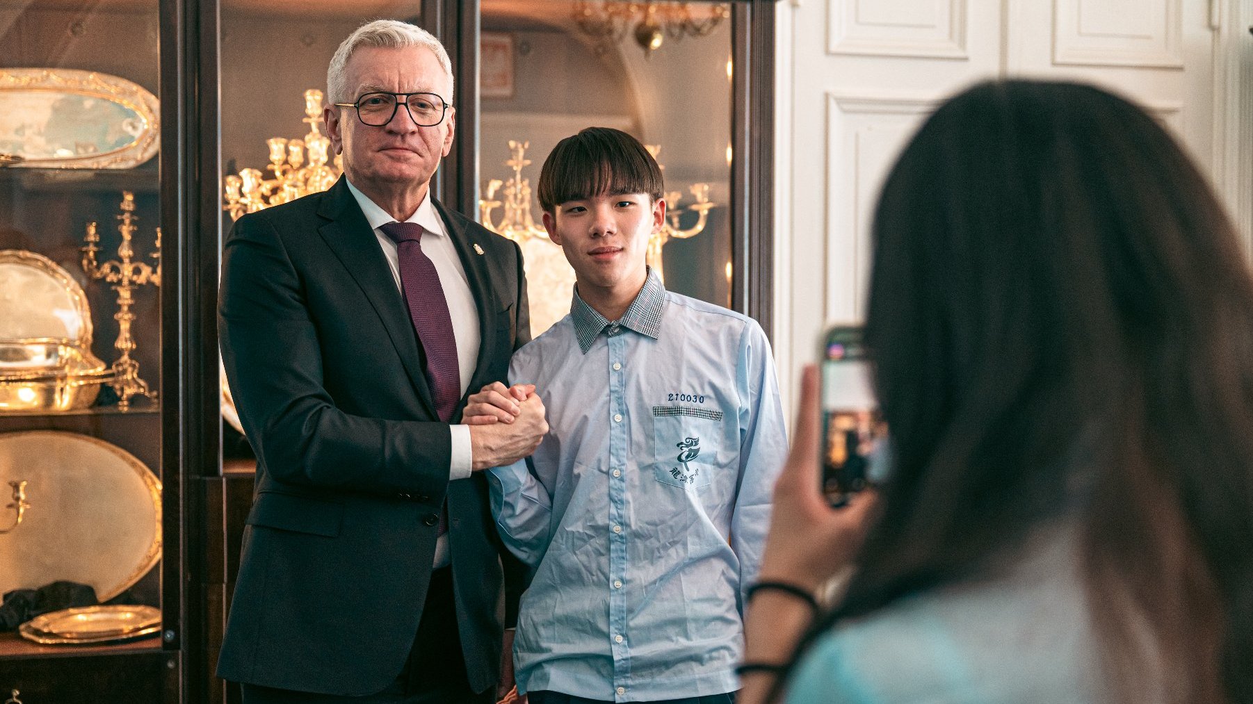 Zdjęcie przedstawia prezydenta i młodego chłopaka pozujących do zdjęcia.