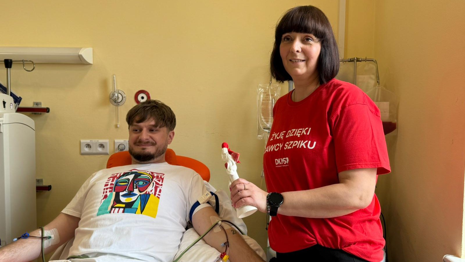 Na zdjęciu mężczyzna oddający szpik, obok niego kobieta w czerwonej koszulce