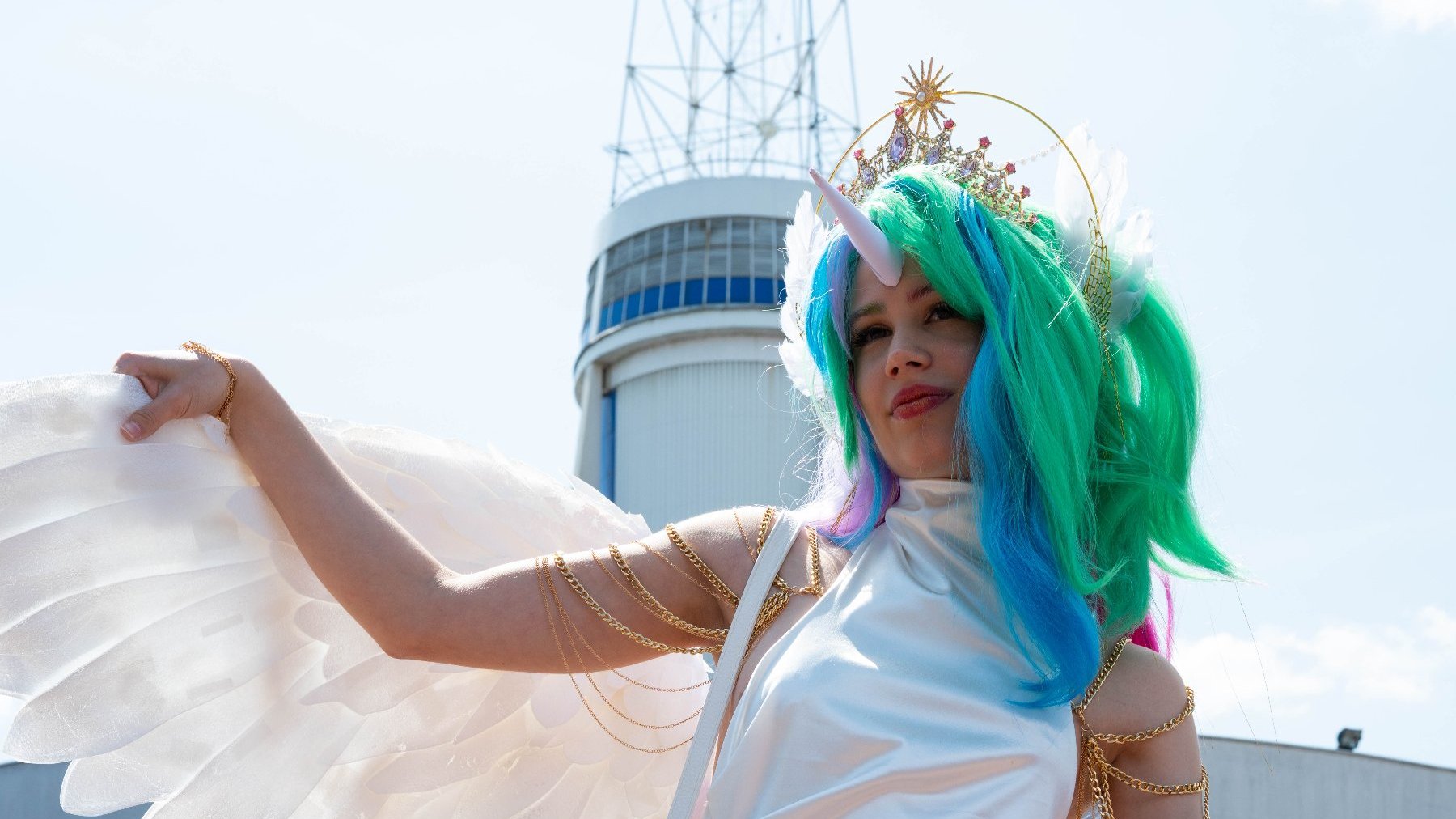 Na zdjęciu cosplayerka w przebraniu jednorożca pozuje na tle Iglicy