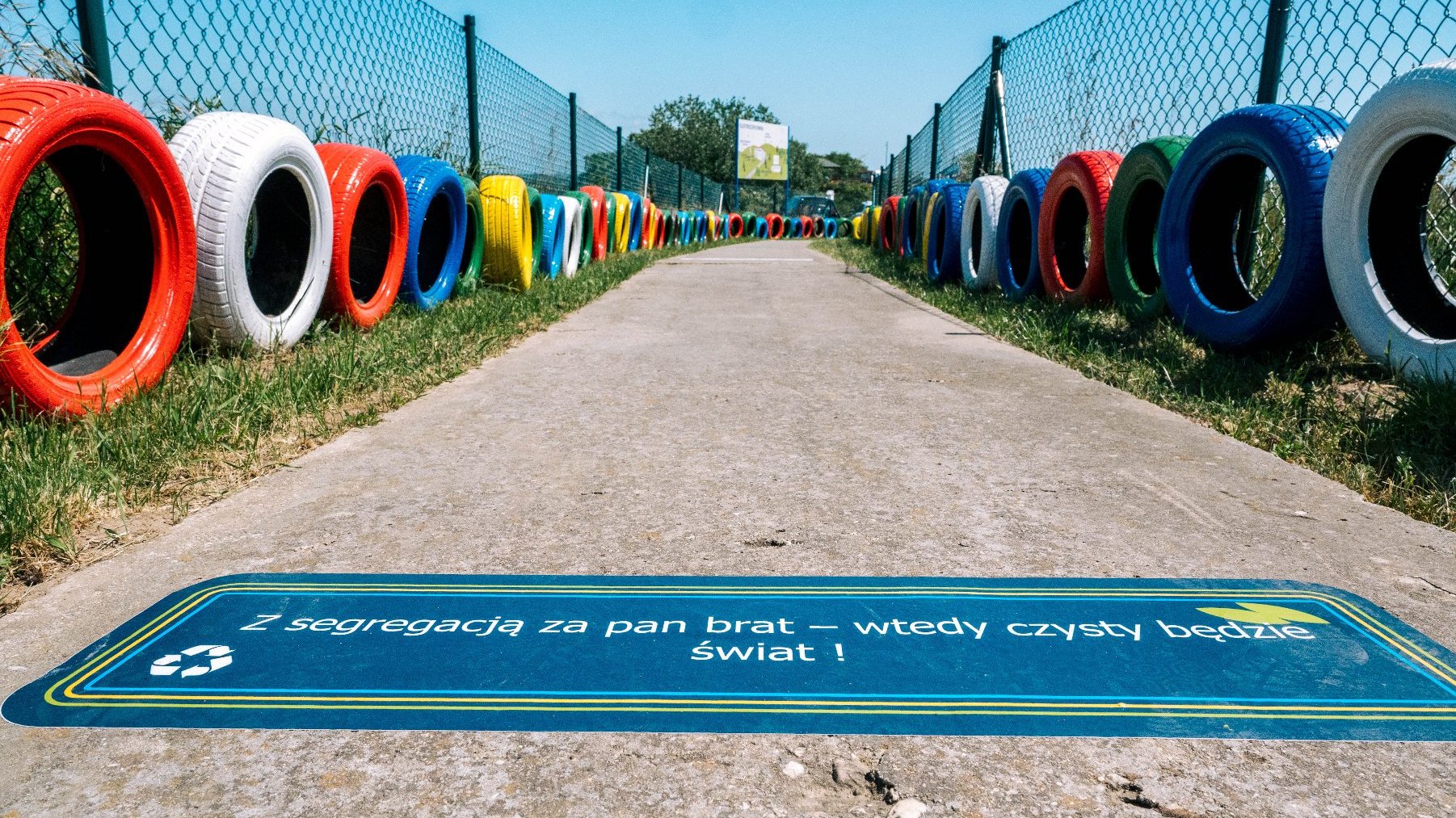 Zdjęcie przedstawia ścieżkę wzdłuż której położone są kolorowe opony.
