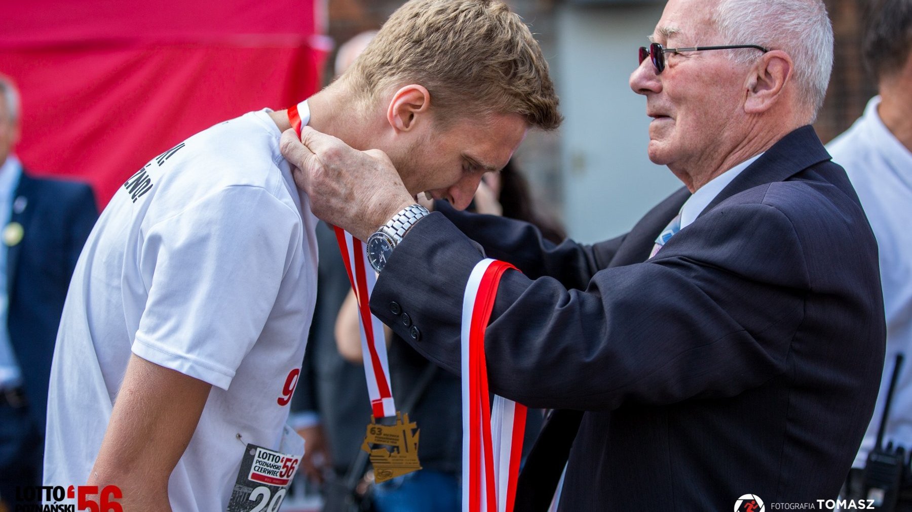 Jerzy Majchrzak wręcza medal biegaczowi