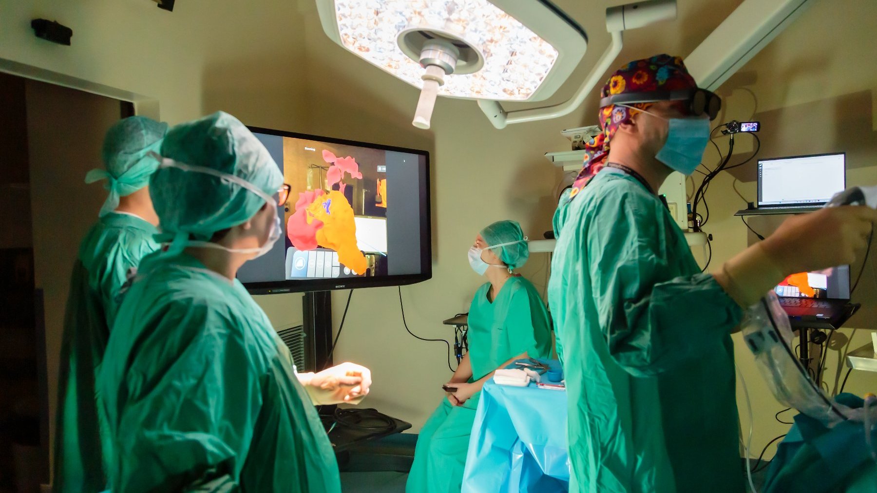 Na zdjęciu lekarze podczas operacji,w tle ekran