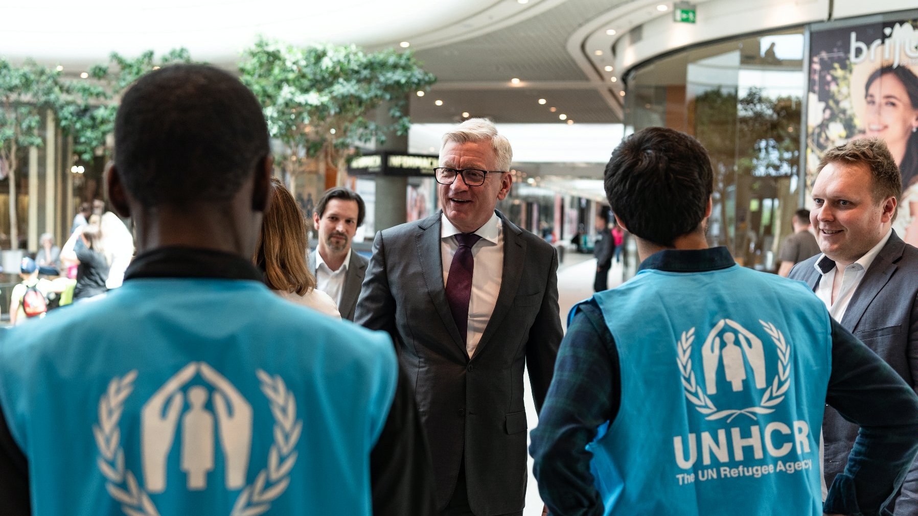 Na zdjęciu Jacek Jaśkowiak, prezydent Poznania, rozmawiający z pracownikami UNHCR, stojącymi tyłem do obiektywu