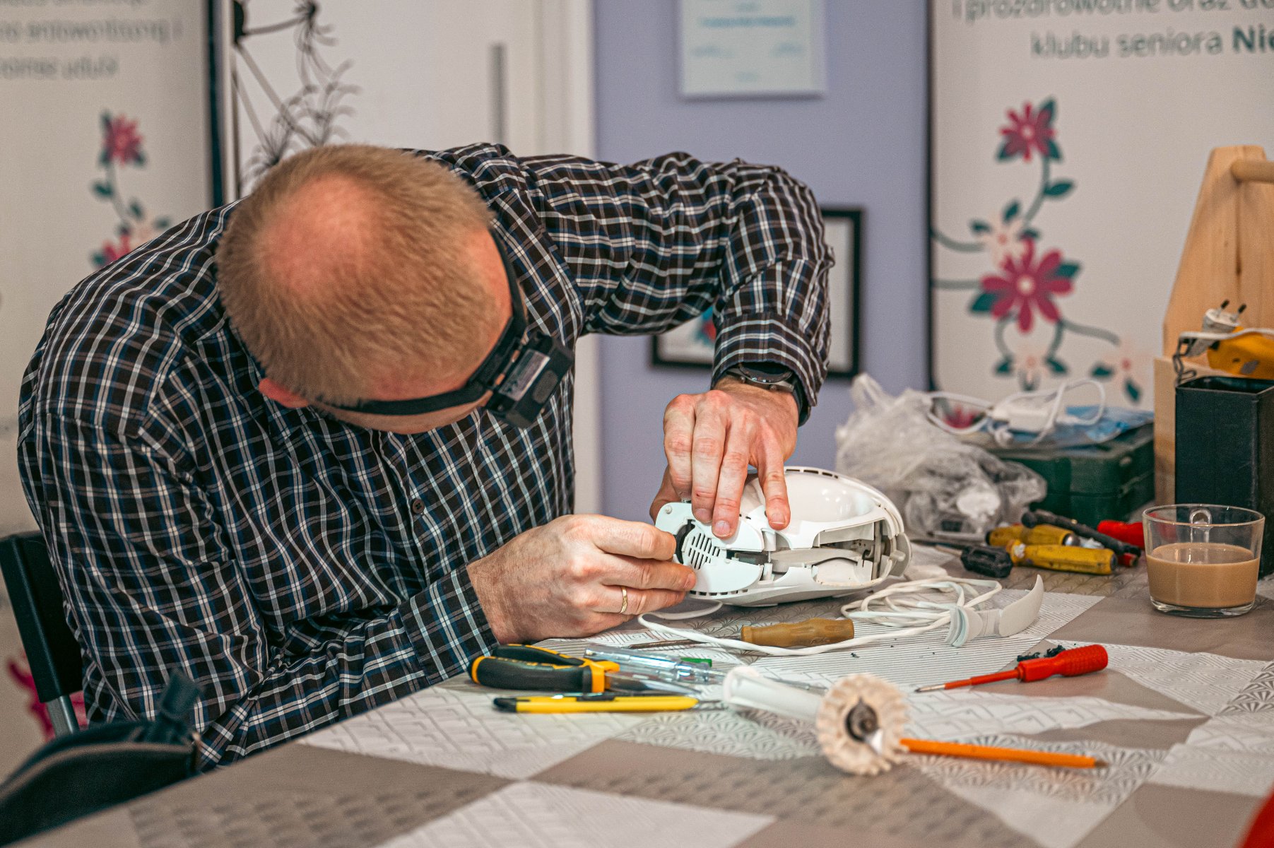 Zdjęcie przedstawia leżące na stole narzędzia i mikser oraz szklankę z kawą.