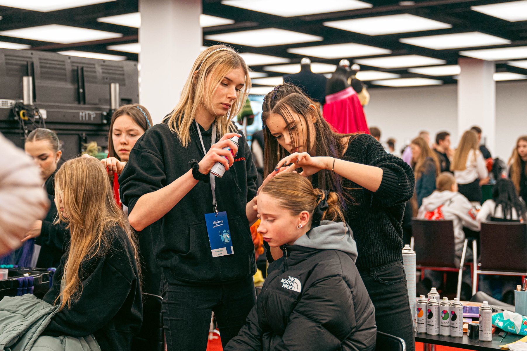 Zdjęcie przedstawia młodych chłopaków naprawiających jakieś urządzenie zawieszone na ścianie.