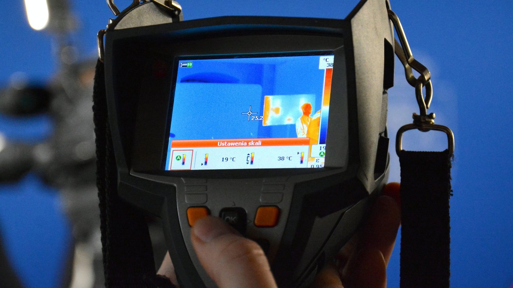 Zdjęcie przedstawia osobę trzymającą kamerę termowizyjną.