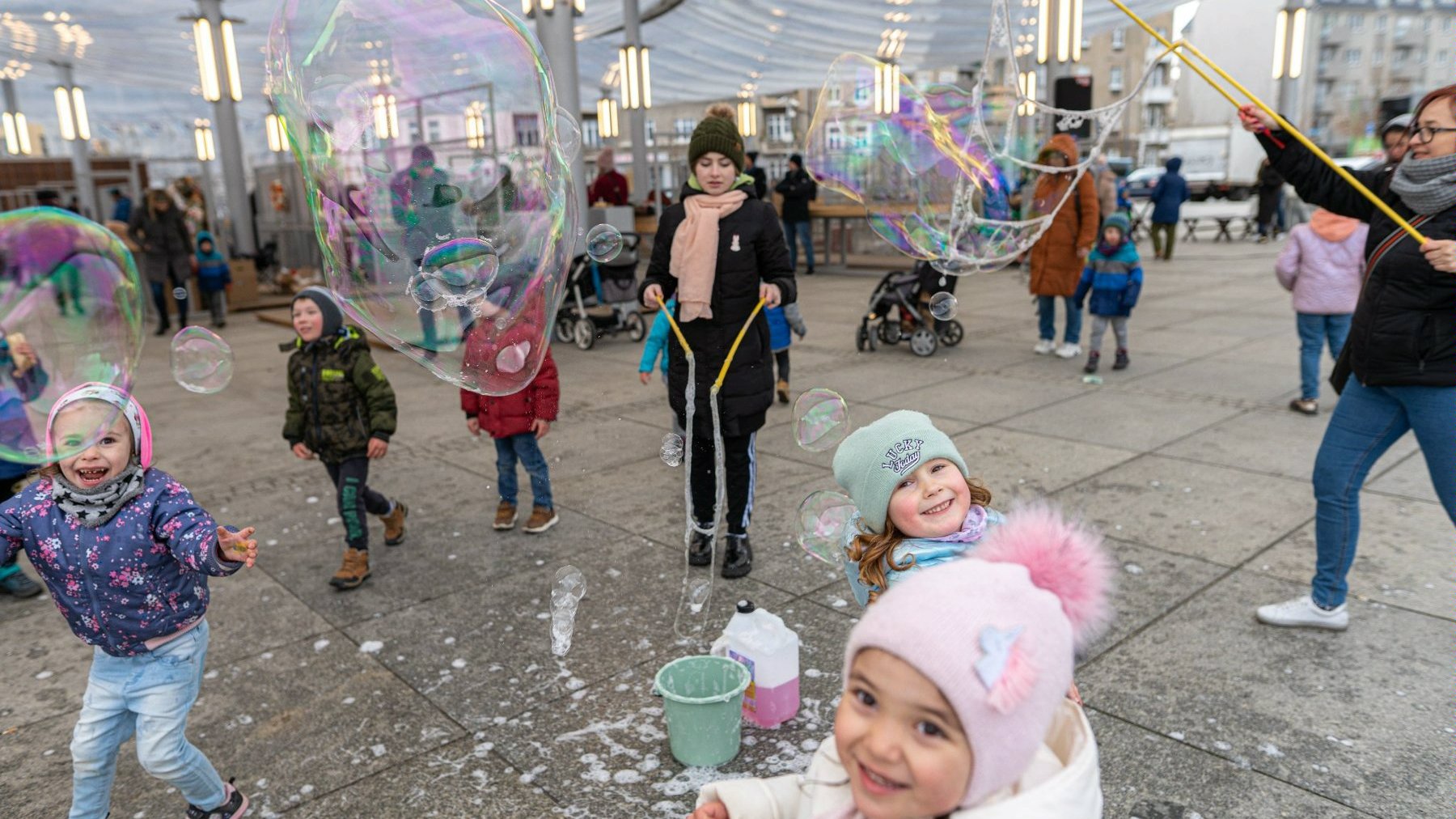 Na zdjęciu dzieci na rynku Łazarskim, bawiące się wielkimi bańkami mydlanymi