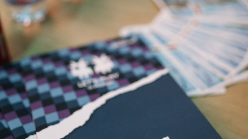 The photo shows "Let's play in Poznań" catalogues spread out in a fan.