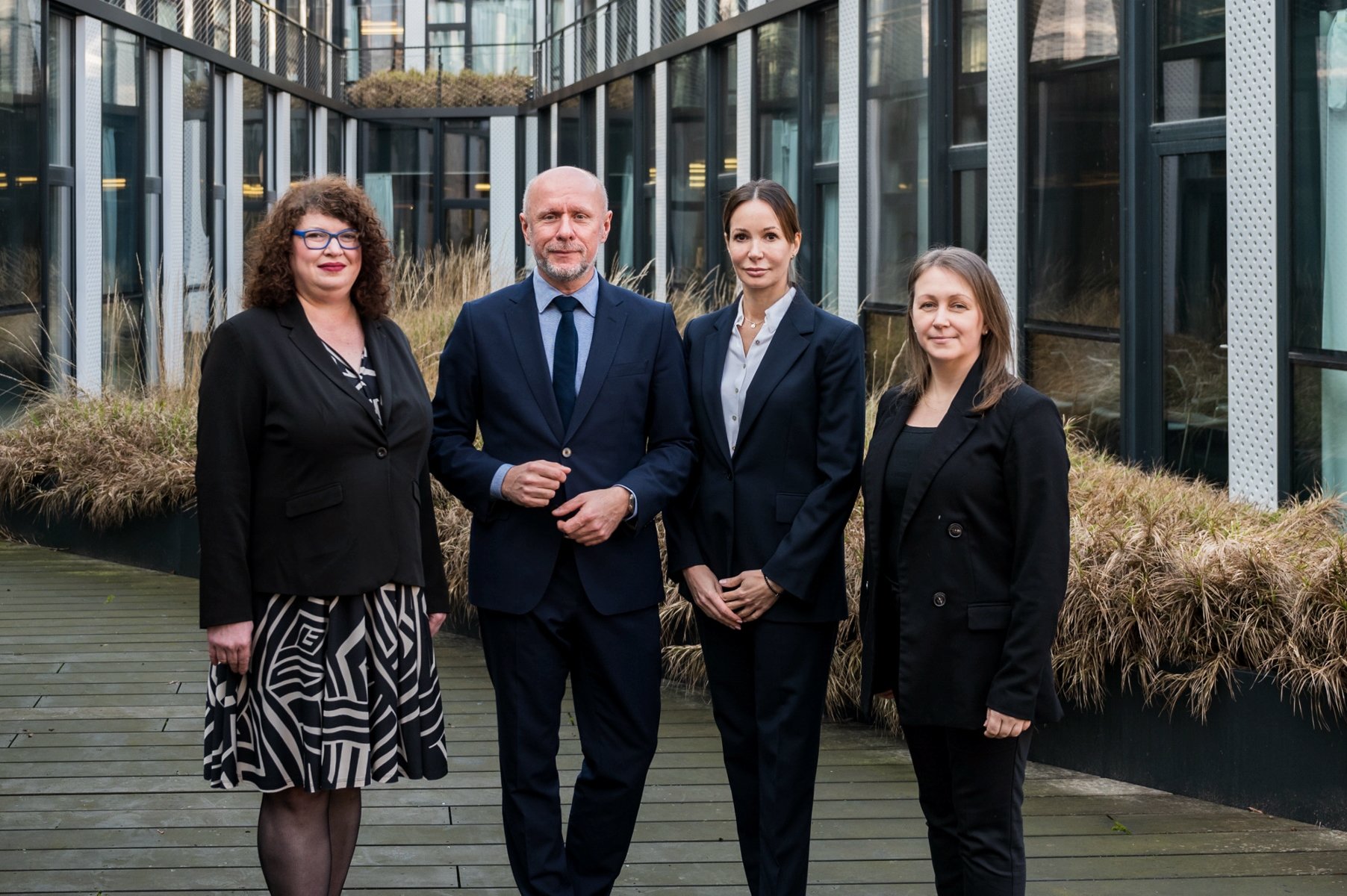 The picture shows City of Poznań officials standing together. From the left you can see: Agnieszka Susicka, Bartosz Guss, Katja Lożina and Dominika Błaszyk. Behind them there is visible grass and office building. - grafika artykułu